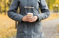 Young woman drinking coffee in an autumn park Royalty Free Stock Photo