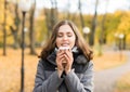 Young woman drinking coffee in an autumn park Royalty Free Stock Photo