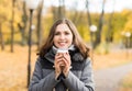 Young woman drinking coffee in an autumn park Royalty Free Stock Photo