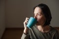 Young woman drinking coffee in a blue mug Royalty Free Stock Photo