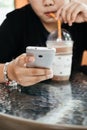 young woman drinking coffee and her using smartphone for checking something at coffee cafe. image for Royalty Free Stock Photo