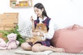 A young woman drinking coffee and holding a Pomeranian dog in the living room where the laptop is placed Royalty Free Stock Photo