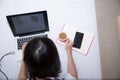 Young woman drinking coffee at home in her bed and checking her laptop, Royalty Free Stock Photo