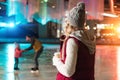 young woman drinking coffee from paper cup and looking at happy family skating behind