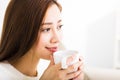Young woman drinking coffee and sitting on sofa Royalty Free Stock Photo