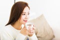 Young woman drinking coffee and sitting on sofa Royalty Free Stock Photo