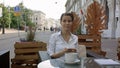 Young woman drinking coffee and using her mobile phone in a outdoor cafe Royalty Free Stock Photo