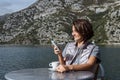 Young woman drinking coffee and using smarphone in the morning a