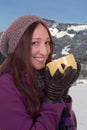 Young woman drinking a cup of hot tea in mountains in winter Royalty Free Stock Photo