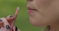 Young woman drinking fresh smoothie through a straw, macro video