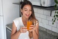 Young woman drinking fresh vitamin juice with carrot and orange in the morning Royalty Free Stock Photo