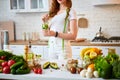 Young woman drinking fresh water with cucumber, lemon and leaves of mint from glass in the kitchen. Healthy Lifestyle and Eating. Royalty Free Stock Photo