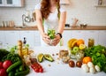 Young woman drinking fresh water with cucumber, lemon and leaves of mint from glass in the kitchen. Healthy Lifestyle and Eating. Royalty Free Stock Photo