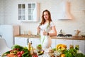 Young woman drinking fresh water from glass and showing thumbs up in the kitchen. Healthy Lifestyle and Eating. Health, Beauty, Royalty Free Stock Photo