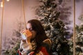 Young woman drinking hot drink from a cup in a snow-covered park Royalty Free Stock Photo