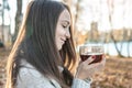 Young woman is drinking hot tea in an autumn Park in the light of the sunset. Cozy lifestyle in the autumn cold season Royalty Free Stock Photo