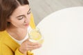 Young woman drinking lemon water at table, above view. Space for text Royalty Free Stock Photo
