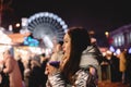 Young woman drinking mulled wine standing in Christmas market