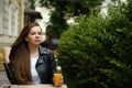 Young woman drinking orange juce in outdoor restaurant