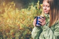 Young Woman drinking tea out of touristic cup Royalty Free Stock Photo