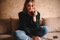 Young woman drinking tea while sitting on sofa Royalty Free Stock Photo