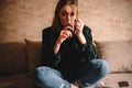 Young woman drinking tea while sitting on sofa Royalty Free Stock Photo