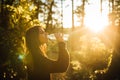 Young woman drinking water from bottle in nature.Bottled water.Hydration.Water intake for healthy body and skin.Natural mineral