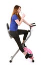 Young woman drinking water on an exercise bike Royalty Free Stock Photo