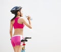 Young woman drinking water and folding bike