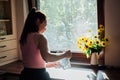 Young woman drinking water from glass in the kitchen. Caucasian female model holding transparent glass in hand. Royalty Free Stock Photo