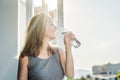 Young woman is drinking water on the sunset background Royalty Free Stock Photo
