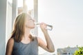 Young woman is drinking water on the sunset background Royalty Free Stock Photo