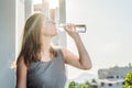 Young woman is drinking water on the sunset background Royalty Free Stock Photo