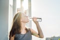 Young woman is drinking water on the sunset background Royalty Free Stock Photo