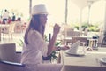 Young woman drinking white wine on outdoor terrace watching on of Mediterranean Sea. Female in white sundress on summer Royalty Free Stock Photo