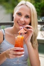 Young woman drinks cocktail outdoor on a hot summer afternoon in Royalty Free Stock Photo