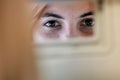 Young woman driver checking rear view mirror looking backwards while driving a car Royalty Free Stock Photo