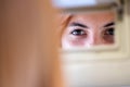 Young woman driver checking rear view mirror looking backwards while driving a car Royalty Free Stock Photo