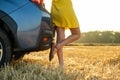 Young woman driver legs in yellow summer dress standing near her car enjoying warm summer day at sunset Royalty Free Stock Photo