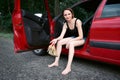 Young woman driver resting in a red car, take off their shoes, happy travel concept, women`s high heel shoes are yellow Royalty Free Stock Photo