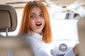 Young woman driving a car backwards. Girl with funny expression on her face while she made a fender bender damage to a rear Royalty Free Stock Photo