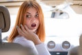 Young woman driving a car backwards. Girl with funny expression on her face while she made a fender bender damage to a rear Royalty Free Stock Photo