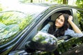 Young woman driving a car in the city. Portrait of a beautiful woman in a car, looking out of the window and smiling. Royalty Free Stock Photo