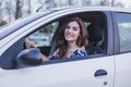 Young woman driving a car in the city. Portrait of a beautiful woman in a car, looking out of the window and smiling. Travel and Royalty Free Stock Photo