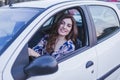 Young woman driving a car in the city. Portrait of a beautiful woman in a car, looking out of the window and smiling. Travel and Royalty Free Stock Photo