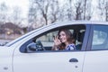 Young woman driving a car in the city. Portrait of a beautiful woman in a car, looking out of the window and smiling. Travel and Royalty Free Stock Photo