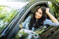 Young woman driving a car in the city. Portrait of a beautiful woman in a car, looking out of the window and smiling. Royalty Free Stock Photo