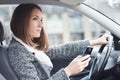 Young woman driving car in the city using phone Royalty Free Stock Photo