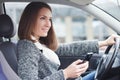 Young woman driving car in the city using phone Royalty Free Stock Photo