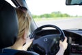 Young woman driving car on a highway. View from the back Royalty Free Stock Photo